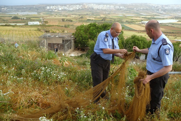 Maltese policemen dismantle a net found by CABS volunteers